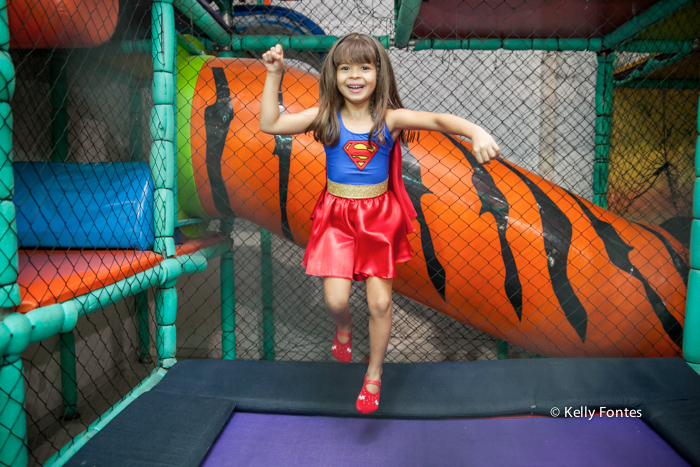 fotos festa infantil rj - bolo mulher maravilha super heróis menina Luisa sorrindo e pulando no brinquedo pula 