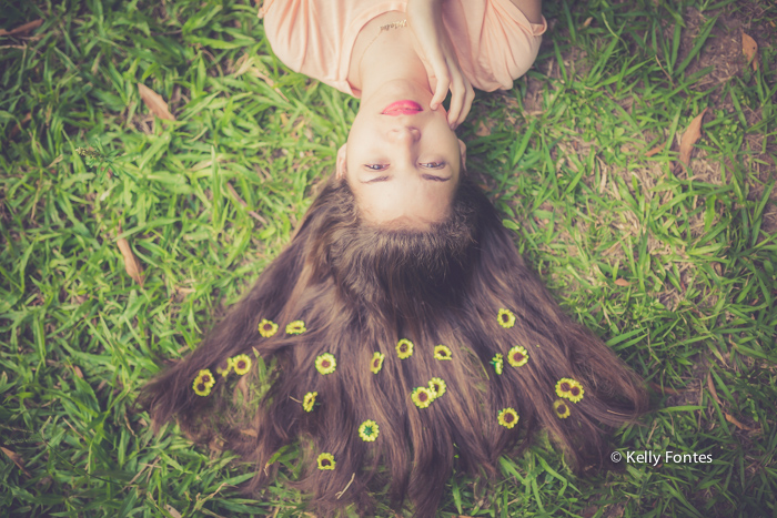 Book 15 anos RJ fotografia debutante no Parque Lage deitada na grama flores no cabelo por fotografo Kelly Fontes