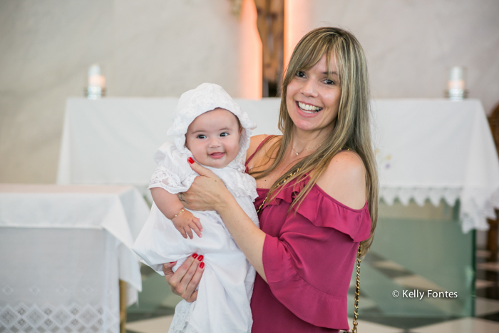 Fotografia Batizado capela santo antonio peninsula rio de janeiro barra da tijuca bebê sorrindo no colo da mamãe RJ